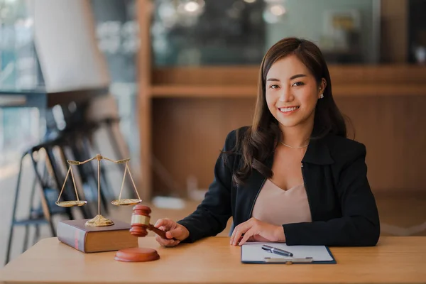 Lawyer\'s Office. An Asian goddess of justice with scales and an Asian female lawyer holding a hammer working in law firms, advice and justice concepts.