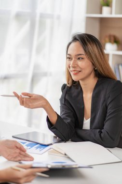 Asian business woman Use a laptop computer and work with the calculator documents on the desk. plan to analyze financial reports Invest in an office business plan