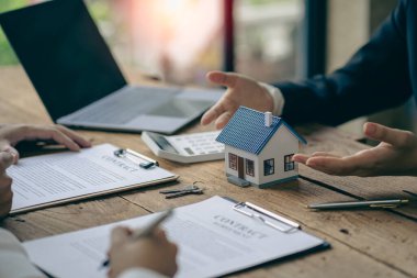 A sales representative is discussing the details before the customer agrees to sign a contract. by explaining the details and terms and conditions of the rental real estate concept