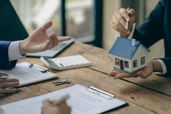A sales representative is discussing the details before the customer agrees to sign a contract. by explaining the details and terms and conditions of the rental real estate concept