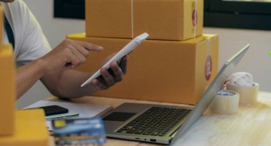 Online store, small business owner, box operator, e-commerce, check website retail order using laptop, prepare parcels, deliver on table. SME business idea.