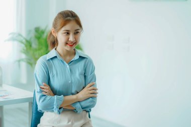Attractive young Asian beauty accountant in office using laptop and financial documents on office desk.