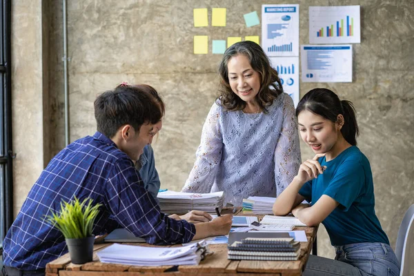 Clever team leader describes an internal meeting with his project team in a modern office. Group of multi-ethnic businessmen in casual wear Project Concepts and Business Finance