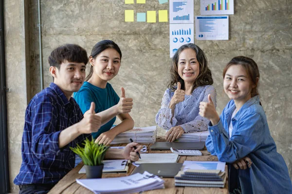 A group of Asian youths with a creative team leader. Have fun laughing with great success. by working as a team Ready to start a business as an entrepreneur brainstorming at a business meeting