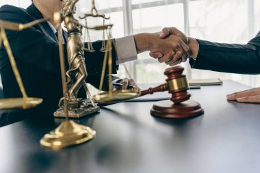 Businessmen shake hands to seal an agreement with a partner lawyer or lawyer who discusses the terms of the contract. The concept of a businessman's legal advisor.