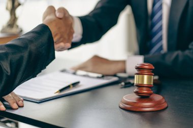 Businessmen shake hands to seal an agreement with a partner lawyer or lawyer who discusses the terms of the contract. The concept of a businessman's legal advisor.