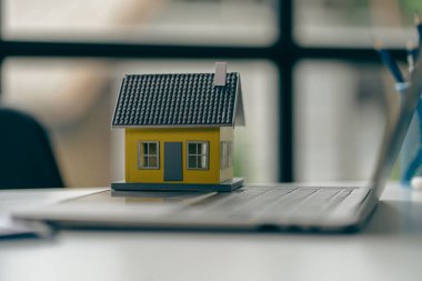 Real estate sales office with example of a house on a businessman's desk.