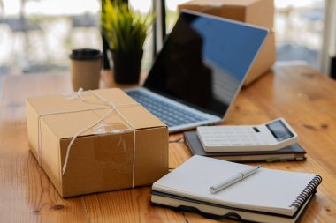 sme business idea with yellow box and laptop on desk in home office