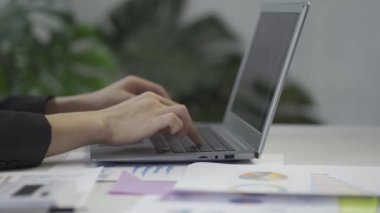 businessman sitting at a desk Work typing on a laptop computer in a contemporary corporate office. financial business technology concept