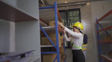 A female Asian warehouse worker checks inventory at the company's warehouse site. delivery concept