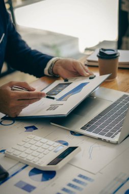 Bir muhasebeci iş muhasebe kavramına bağlı kalırken bir hesap makinesi ve bilgisayar kullanır. Bütçe ve Kredi Elleri, ofis dikey resminde para kazanan ve harcamaları hesaplayan insanların elleri