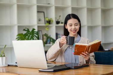 Asian woman working in office with laptop and tablet online working concept