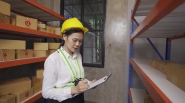 female worker checking goods in warehouse for delivery