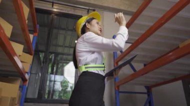 female worker checking goods in warehouse for delivery