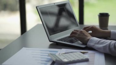 Businesswoman accountant using a calculator to calculate expenses analyze financial data at home
