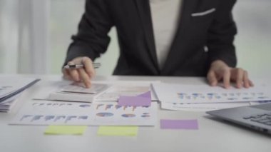 Businesswoman accountant using a calculator to calculate expenses analyze financial data at home