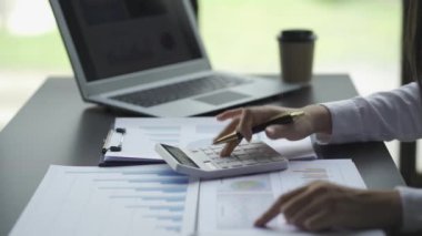 Businesswoman accountant using a calculator to calculate expenses analyze financial data at home