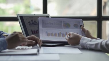 male businessman and female accountant Calculate using a calculator and take notes. Analyze the financial statements in the company office in the meeting room.
