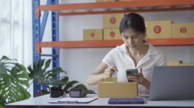 A woman in an e-commerce business inspecting the product before sending it to the customer. She does business on websites and social media. concept of selling products online sme