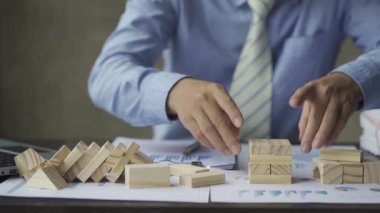 Businessman building a tower with wooden blocks The idea of building a real estate business