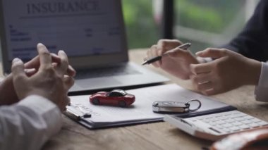 Şık takım elbiseli bir araba satıcısı başarılı iş adamlarına bir araba markası seçimi sunuyor ve araba galerisi sigortası taksitleri için faiz oranları sunuyor..