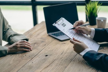 Dost canlısı İK yöneticileri iş görüşmelerini yönetir ve ofis masasındaki adaylardan biriyle özgeçmişlerini okurlar..