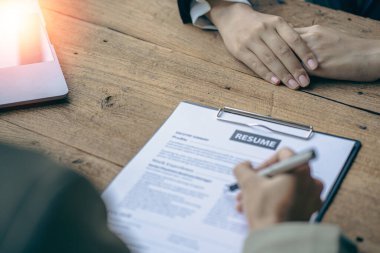 Dost canlısı İK yöneticileri iş görüşmelerini yönetir ve ofis masasındaki adaylardan biriyle özgeçmişlerini okurlar..