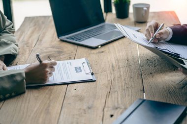 Dost canlısı İK yöneticileri iş görüşmelerini yönetir ve ofis masasındaki adaylardan biriyle özgeçmişlerini okurlar..