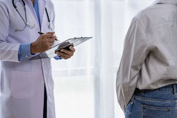 Doctor and patient consulting and diagnosis sitting at a table with advice of medicines to eat near window in hospital medical concept