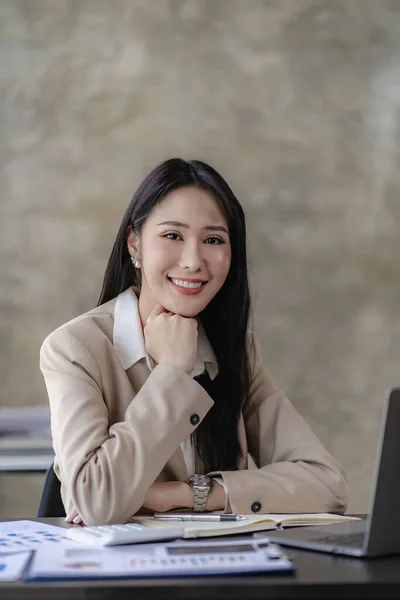 Smiling Asian businesswoman working on laptop in modern office, accountant, concept, analysis, business, report, graph, financial chart corporate economy, banking, market research