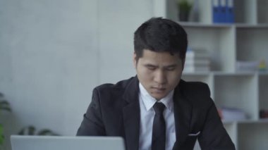 Genç Asyalı işadamı, defter, bütçe, vergi, finansal dökümanlar kullanırken gelir ve ev harcamalarını kaydediyor. Ev ekonomisi konsepti 4k 'de oturma odasında çalışmak.