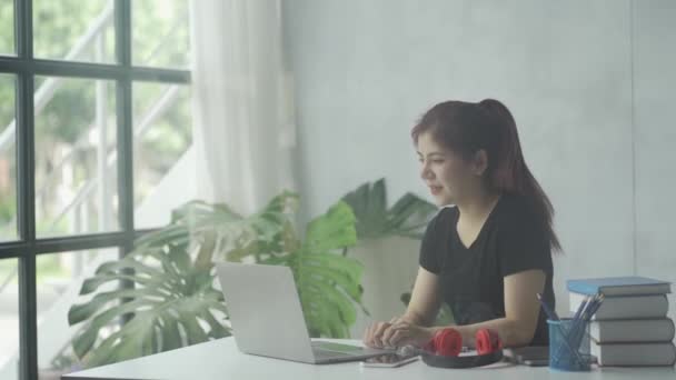 ラップトップとオンライン教育の概念グリッドで本を持つアジアの女性 — ストック動画