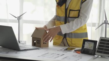 Asyalı bir kadın mühendis rüzgar türbinleri ve güneş panellerinden oluşan bir elektrik santrali inşa etmeyi planlıyor..