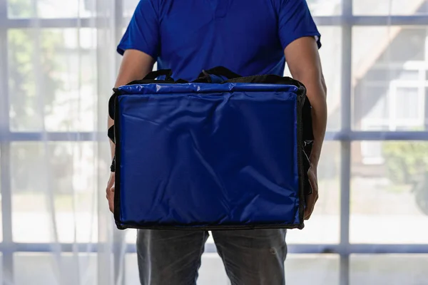 Young man carrying a blue bag, express food delivery, service concept