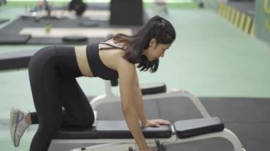 Güçlü ve sağlıklı olmak için kas esnetme egzersizi yapan çekici Asyalı kız spor salonu, egzersiz konsepti..