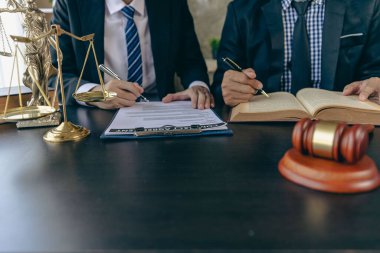 İşadamı ve avukat kontrat belgelerini altın pullarla tartışıyor, adalet tanrısı, hukuk bürosundaki ahşap masa üzerinde sarı, tavsiye, adalet kavramı