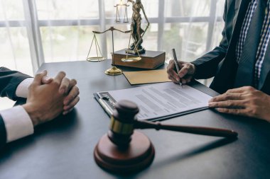 İşadamı ve avukat kontrat belgelerini altın pullarla tartışıyor, adalet tanrısı, hukuk bürosundaki ahşap masa üzerinde sarı, tavsiye, adalet kavramı