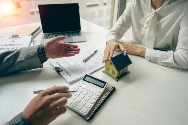 Emlak acenteleri yeni ev alıcılarıyla konuşur, iyi faiz oranları teklif eder ve emlak konsepti kararlarının alınmasına yardımcı olmak için ipotek finansmanında müşterileri hesaplar..