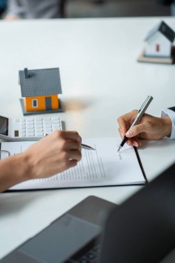 Emlak acenteleri yeni ev alıcılarıyla konuşur, iyi faiz oranları teklif eder ve emlak konsepti kararlarının alınmasına yardımcı olmak için ipotek finansmanında müşterileri hesaplar..