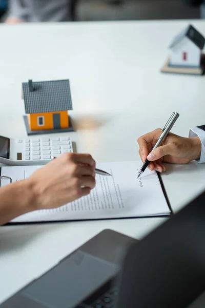 Home agents talk to new home buyers and offer good interest rates and calculate clients on mortgage financing to help make real estate concept decisions.