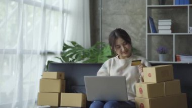 Bir e-ticaret kadını müşterileri göndermeden önce onların bir listesini yazar. KOBİ işini internet sitesinde ve sosyal medyada dizüstü bilgisayarıyla yürütüyor. çevrimiçi ürün satma kavramı