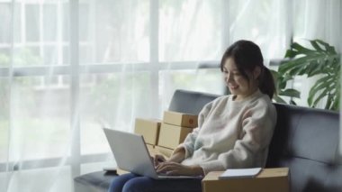 Bir e-ticaret kadını müşterileri göndermeden önce onların bir listesini yazar. KOBİ işini internet sitesinde ve sosyal medyada dizüstü bilgisayarıyla yürütüyor. çevrimiçi ürün satma kavramı