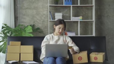 Bir e-ticaret kadını müşterileri göndermeden önce onların bir listesini yazar. KOBİ işini internet sitesinde ve sosyal medyada dizüstü bilgisayarıyla yürütüyor. çevrimiçi ürün satma kavramı