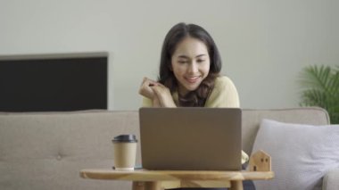 Uzun saçlı çekici bir Asyalı kadın, siyah, çalışan, elleri kullanan, dizüstü bilgisayarı olan, evinde çalışan, neşeli, taze, dışa dönük, rahat bir yaşam tarzı olan bir kadın.