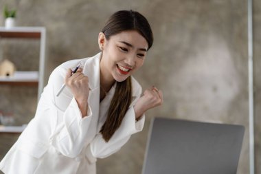 Güzel Asyalı iş kadını diz üstü bilgisayarla kutluyor başarılı duruş ekommerce üniversite eğitimi İnternet teknolojisi veya küçük işletme fikirleri başlatıyor