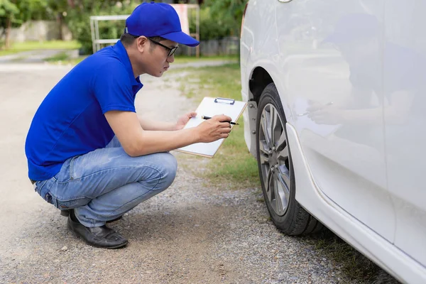 A man checking and fixing a broken car on the side of the road. Problems with broken cars on the highway Man looking under the hood of a roadside assistance concept car.