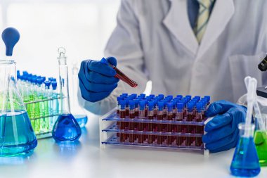 Bilimadamları laboratuvar tıbbi konseptinde üzerinde kan olan bir test tüpünü tutuyorlar.
