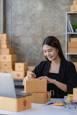 Küçük işletmeler kuran KOBİ 'li kadın girişimciler fatura kutusuna adresi yazın ve kutuları paketlemek, müşterilere satmak, iş fikirlerini çevrimiçi olarak satmak için online siparişleri işaretleyin.