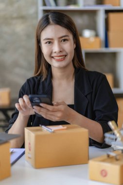 Küçük işletmeler kuran KOBİ 'li kadın girişimciler fatura kutusuna adresi yazın ve kutuları paketlemek, müşterilere satmak, iş fikirlerini çevrimiçi olarak satmak için online siparişleri işaretleyin.