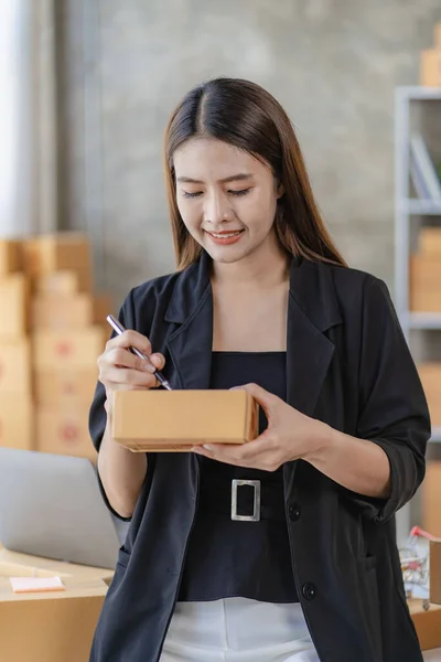 Starting small businesses SME owners female entrepreneurs Write the address on receipt box and check online orders to prepare to pack the boxes, sell to customers, sme business ideas online.